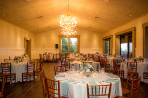round Tables set for wedding dinner under chandeliers at Paradise Ridge winery