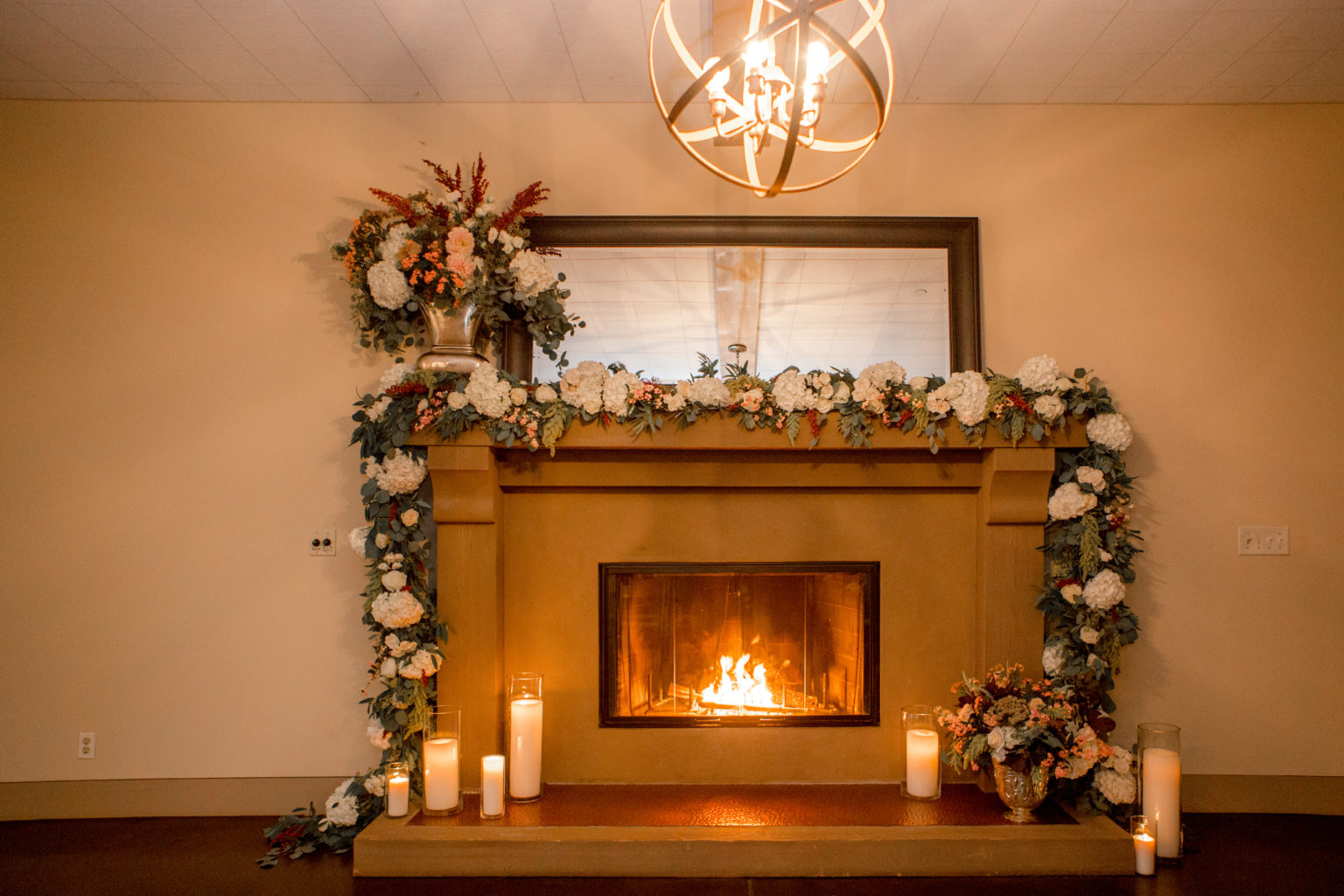 Fireplace draped with wedding florals and candles at Paradise Ridge winery