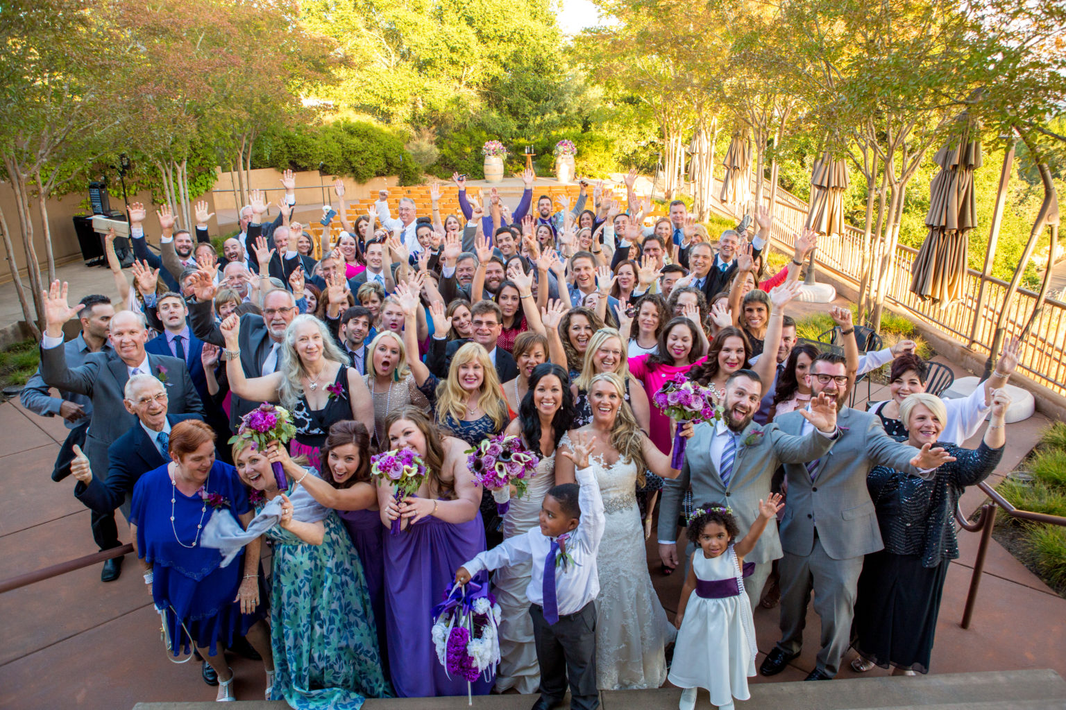 Wedding couple and guests throwing their arms up in celebration at Paradise Ridge winery