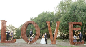 Wedding party spread out inside the life sized metal "Love" sign at Paradise Ridge winery